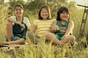 Filmstill ANITA'S LAST CHA CHA, Ang Huling Cha-Cha Ni Anita, Film von Sigrid Andrea P. Bernardo, drei grinsende Kinder auf Wiese