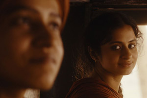 Film Still QISSA – DER GEIST IST EIN EINSAMER WANDERER von Anup Singh mit Irrfan Khan und Tisca Chopra, die als Junge aufgezogene Kanwar (gespielt von Tillotama Shome) und ihre Verlobte Neeli (gespielt von Rasika Dugal) liegen voneinander abgewandt auf dem Bett