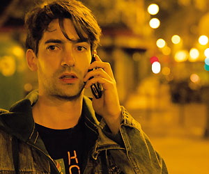 Filmstill Théo & Hugo (2016), Original: Théo et Hugo dans le même bateau, von Olivier Ducastel & Jacques Martineau; Hugo (gespielt von François Nambot) telefoniert mit seinem Mobiltelefon auf den nächtlichen Straßen von Paris
