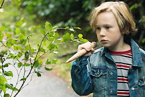 Film-Still CLOSET MONSTER von Stephen Dunn mit Connor Jessup, Aliocha Schneider und Isabella Rossellini; der junge Oscar läuft mit einem Holzpflock in der Hand herum