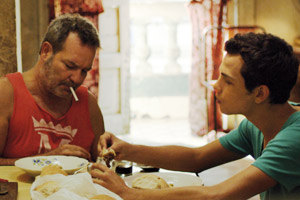 Film Still VIVA von Paddy Breathnach mit Héctor Medina, Jorge Perugorría, Luis Alberto García und Renata Maikel Machin Blanco; Jesús (gespielt von Héctor Medina) und sein Vater Angel (Jorge Perugorria) sitzen zusammen am Essenstisch