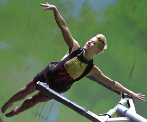 Film Still BORN TO FLY: ELIZABETH STREB VS. GRAVITY (Deutschland-Premiere) von Catherine Gund; eine Tänzerin schwebt in einer sich drehenden Vorrichtung