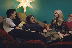 Film Still I LOVE YOU BOTH von und mit Doug Archibald; Donny (gespielt von Doug Archibald) und seine Zwillingsschwester Krystal (gespielt von Kristin Archibald) liegen zusammen auf einem Bett und in ihrer Mitte liegt Andy (gespielt von Lucas Neff) unter einer Sternenlampe