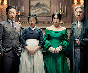 Film Still THE HANDMAIDEN von Park Chan-wook; Verfilmung von Sarah Waters' Roman "Fingersmith"; vor einem Kamin stehen der Graf Fujiwara (gespielt von Jung-woo Ha), das Dienstmädchen Sook-Hee (gespielt von Tae Ri Kim), Lady Hideko (gespielt von Min-hee Kim) und Onkel Kouzuki (gespielt von Jin-woong Jo)