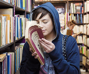 Film Still TAKE ME FOR A RIDE – UIO: SÁCAME A PASEAR von Micaela Rueda; Schülerin Sara (gespielt von Samanta Caicedo) steckt in einer Bibliothek ganz wörtlich die Nase in ein Buch