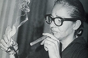 Film Still CHAVELA von Catherine Gund und Daresha Kyi über die lateinamerikanische Ranchera-Sängerin Chavela Vargas mit Pedro Almodóvar; Chavela zündet sich eine Zigarre an