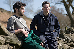 Film Still GOD'S OWN COUNTRY von Francis Lee; Sundance und Berlinale 2017; Johnny (gespielt von Josh O’Connor) und Gheorghe (gespielt von Alec Secareanu) machen eine Pause an einer alten Steinmauer