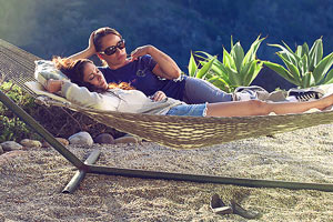 Film Still MILLIONEN MOMENTE VOLLER GLÜCK – A MILLION HAPPY NOWS von Albert Alarr; Lainey Allen (gespielt von Crystal Chappell) und ihre Lebenspartnerin Eva Morales (gespielt von Jessica Leccia) liegen zusammen in einer Hängematte