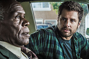 Film Still PUSHING DEAD von Tom E. Brown mit James Roday, Danny Glover, Robin Weigert, Khandi Alexander und Tom Riley; Dan Schauble (gespielt von Roday) dreht sich im Auto zu Kneipier Bob (gespielt von Glover) um