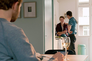 Film Still CAS von Joris van den Berg mit Kevin Hassing, Wieger Windhorst und Felix Meyer; Pepijn (gespielt von Windhorst) steht mit einer Freundin bei einer Privatparty in der hellen Küche
