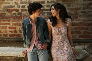 Film Still CALL ME BY YOUR NAME von Regisseur Luca Guadagnino; Elio Perlman (gespielt von Timothée Chalamet) steht eng neben Marzia (gespielt von Esther Garrel) vor einer Ziegelmauer
