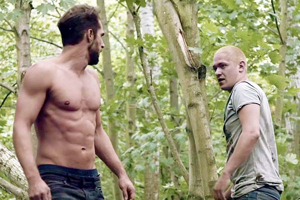 Film Still JAHR DES TIGERS – THE YEAR I LOST MY MIND, ein queerer Berlin-Thriller von Tor Iben mit Patrick G. Boll, Michael del Coco und Christian Harting; der verkappt schwule Dieb Tom (gespielt von Alexander Tsypilev) und der Geschichtsdozent Lars (gespielt von Julien Lickert) mit entblößtem Oberkörper umkreisen sich aggressiv auf einer Waldlichtung