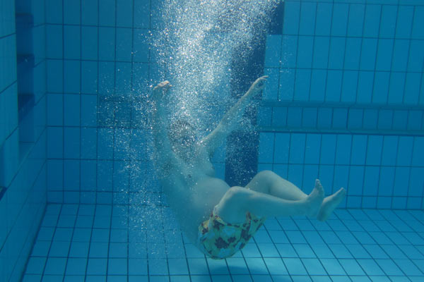 Film Still A DEAL WITH THE UNIVERSE vom transsexuellen Filmemacher Jason Barker aus England, 2018; Jason Barker taucht mit vielen Luftblasen in ein Schwimmbecken unter