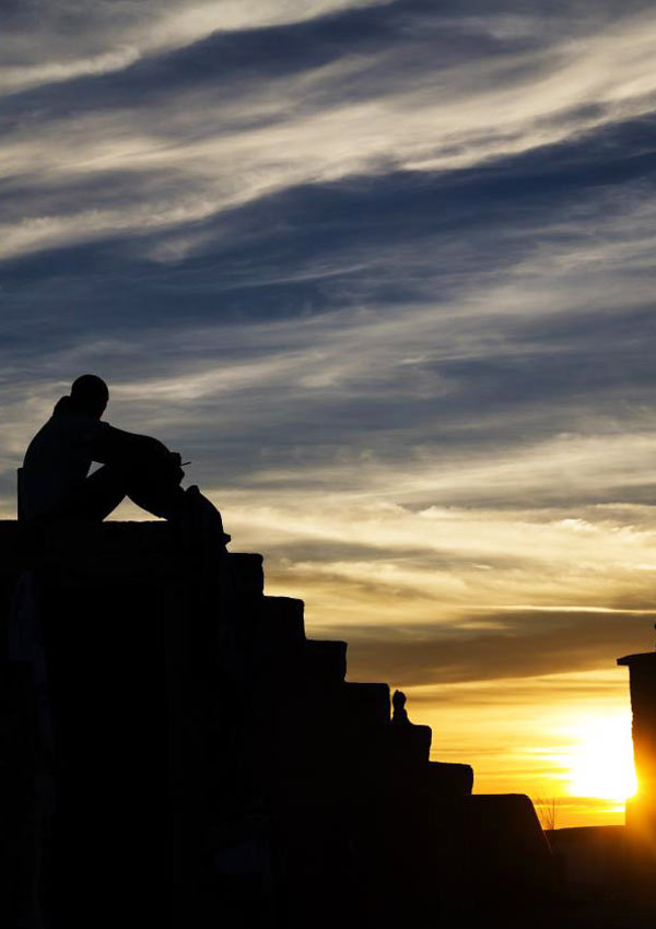 Film Poster AEFFETTO DOMINO von Regisseur, Autor, Ko-Editor und Hauptdarsteller Fabio Massa aus Italien, 2016; Lorenzo (gespielt von Fabio Massa) sitzt auf Stufen vor einem Abendhimmel mit Sonnenuntergang und zeichnet sich als Umriss ab