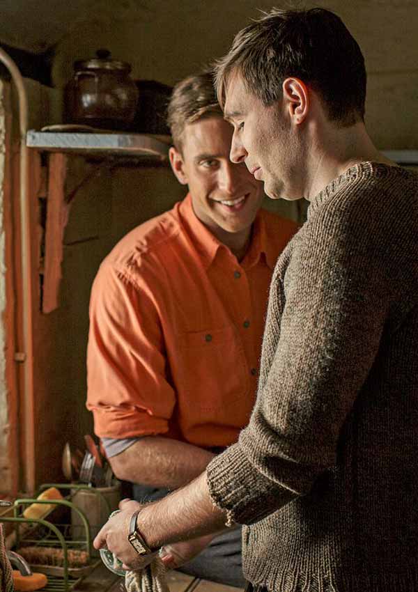 Film Still MAN IN AN ORANGE SHIRT von Regisseur Michael Samuels, BBC-Zweiteiler aus GB, 2017; Michael Berryman (gespielt von Oliver Jackson-Cohen) steht in orangem Hemd neben Maler und Thomas March (gespielt von James McArdle), der im Cottage den Abwasch macht